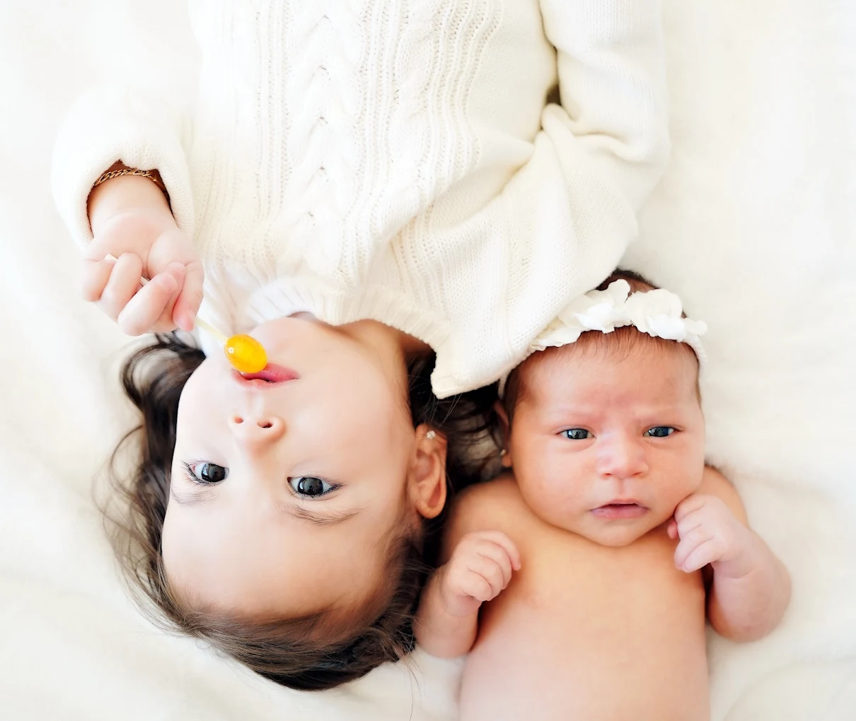 Baby and big sister closeup during a sibling photography session