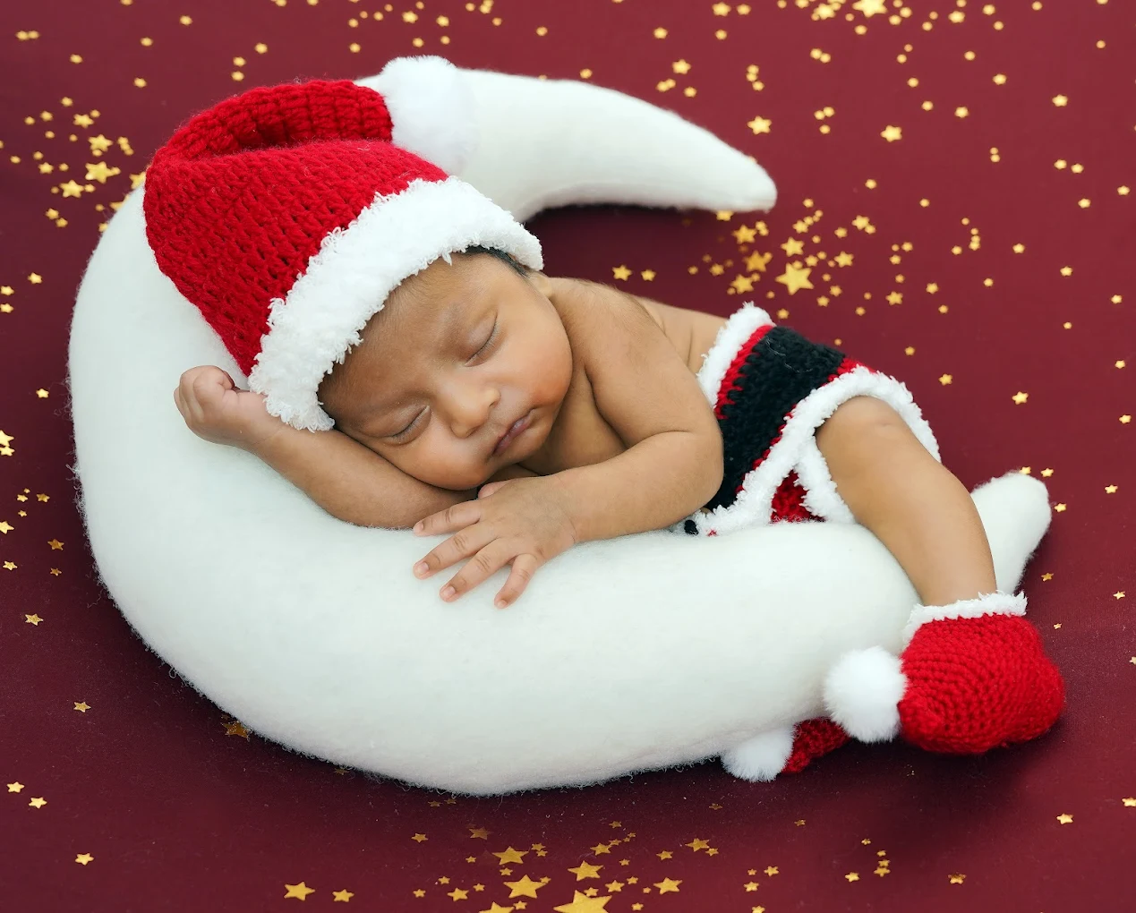 Newborn baby dressed as little Santa sleeping during a holiday themed photography session in McAllen, TX