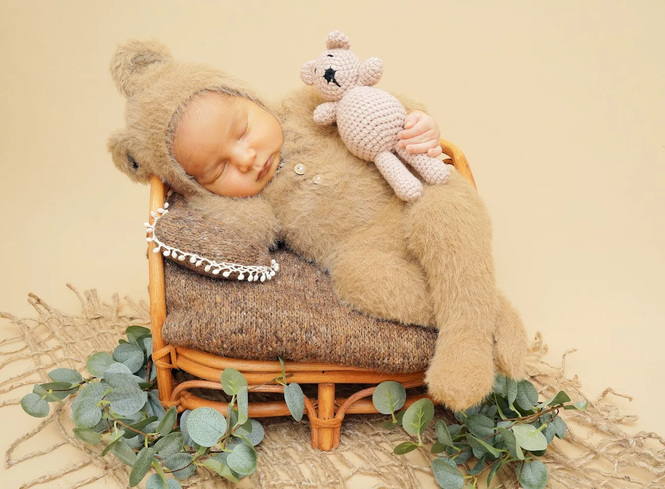 Newborn baby sleeping in a cute bear costume during a professional photography session near McAllen, Texas