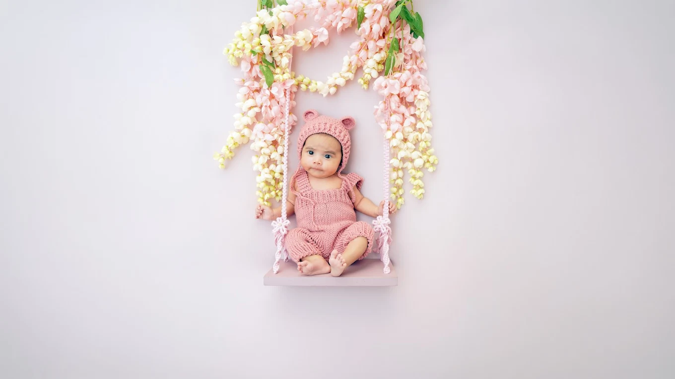 Cute baby sitting in a swing prop during a milestone photography session at Adrisabel Photography near Edinburg, Texas