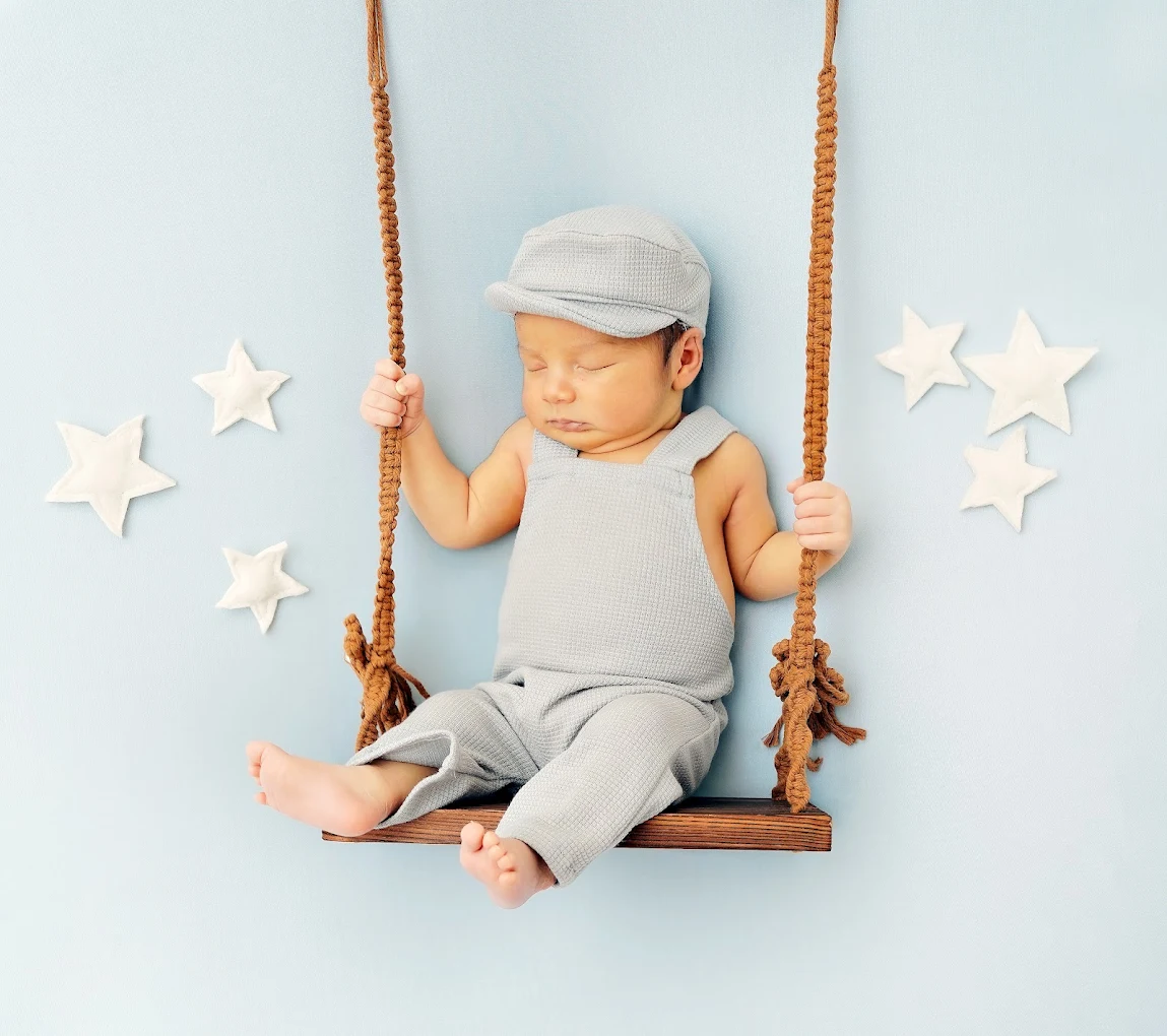 Baby boy in blue themed swing during a professional photo session